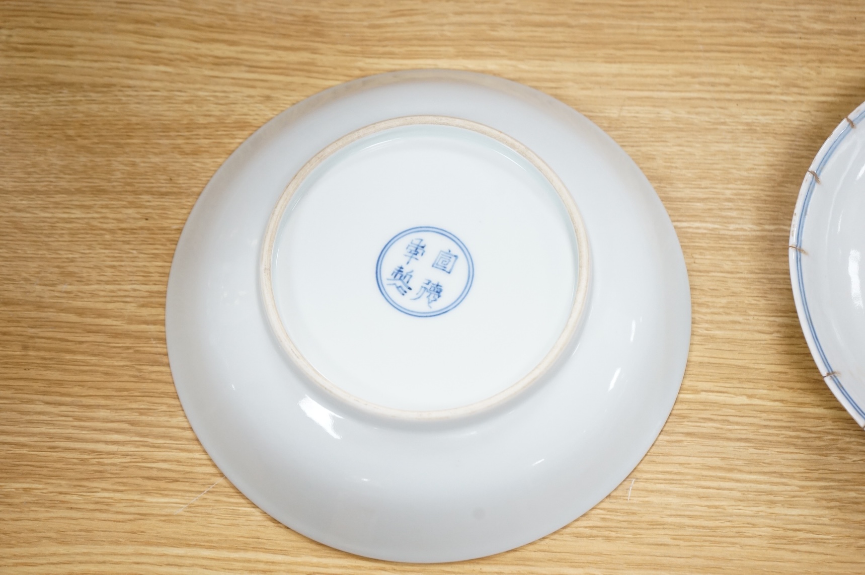 A Chinese underglaze copper red ‘fish’ dish and a blue and white dish, Zhengde mark but later, largest 22cm